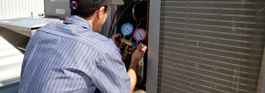 HVAC technician servicing a condenser unit in Golden Valley
