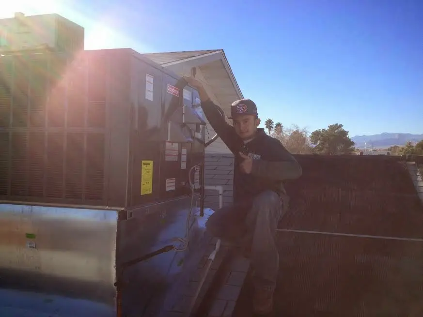 HVAC technician performing Air Duct Repair on a rooftop unit in Golden Valley